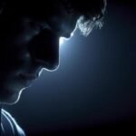 person-in-dark-room-wearing-headphones-lit-from-above-photo