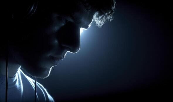 person-in-dark-room-wearing-headphones-lit-from-above-photo